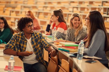Studierende unterhalten sich im Hörsaal