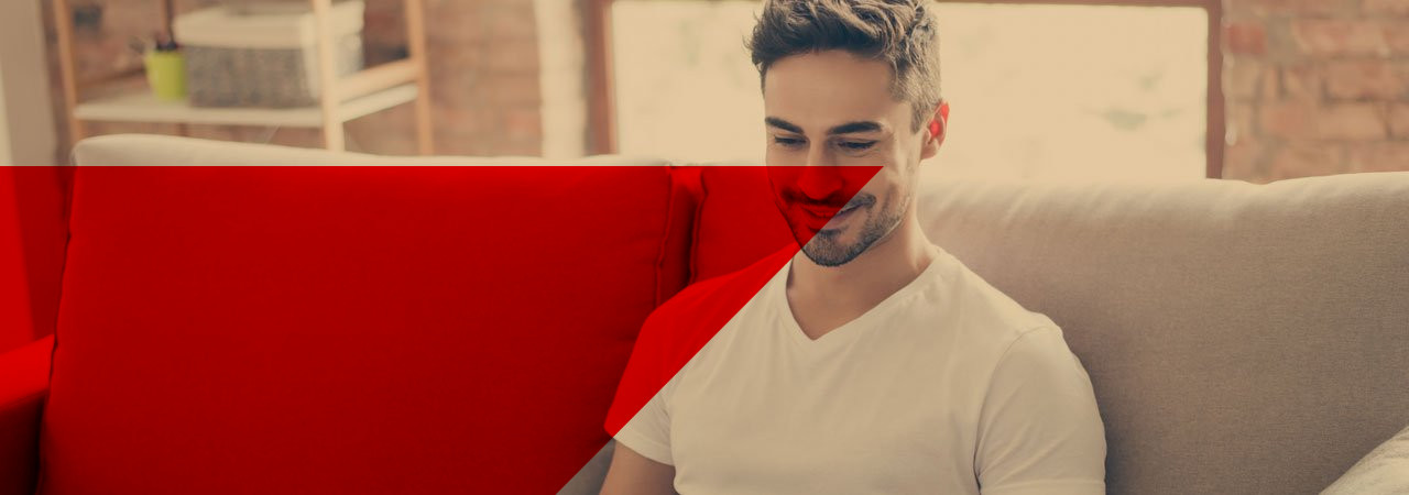 Mann sitzt mit dem Laptop auf der Coach