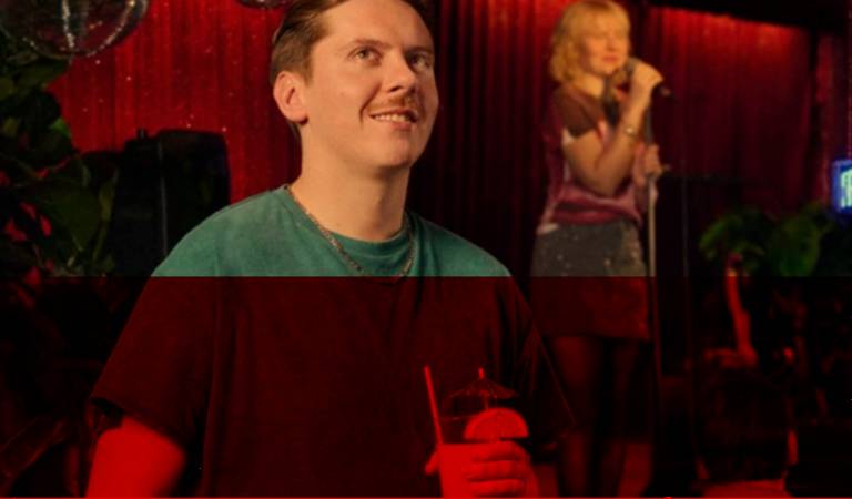 Junger Mann mit Drink im Club