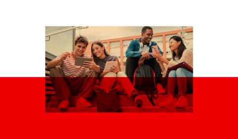 Junge Menschen sitzen auf der Treppe und schauen ins Handy