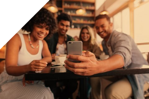 Junge Leute am Tisch, die aufs Handy schauen