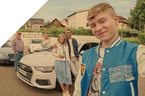 Junger Mann mit seinen Eltern stehen vor ihrem Auto